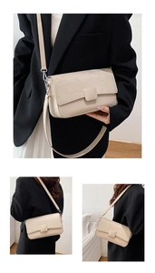 Detail view of a minimalist cream flap crossbody bag with square buckle and adjustable strap