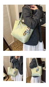 Detail of mint green PU leather tote bag with bear charm and soft textured surface