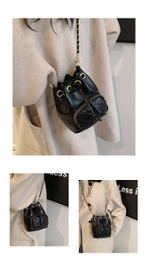 Gros plan détaillé d'un sac seau en cuir matelassé noir avec chaîne dorée et cordon