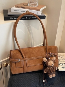 Vintage brown suede tote bag with minimalist strap detail and cute teddy bear pendant