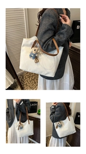 Detailed shot of white leather tote bag with brown straps and cute bear charm pendant