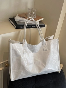 Minimalist white large capacity tote bag with embossed text on a black seat