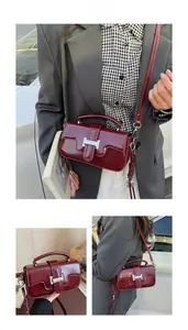 Close-up of wine red glossy leather crossbody bag with silver buckle and woven strap details