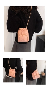 Détail du sac seau rose matelassé avec bandoulière en chaîne et cordon de serrage
