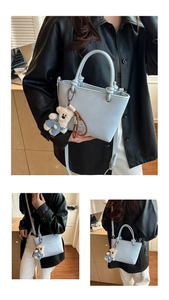 Detail of light blue tote bag featuring MIAOSHE lettering and cute teddy bear charm