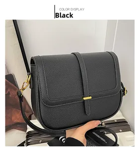 Détail du sac carré en cuir noir grainé avec des accessoires métalliques dorés fins