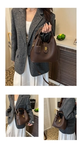 Detail of dark brown pebble leather bucket bag with gold clasp and adjustable strap