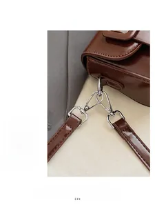 Close-up of the silver metal hook and glossy dark brown leather on the baguette bag