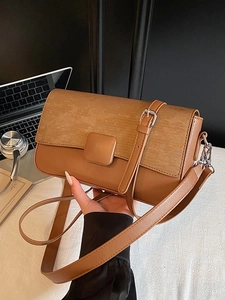 Minimalist caramel patchwork crossbody bag shown in a professional office setting