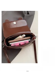 Detailed interior of a brown saddle bag showing ample space for phone and makeup