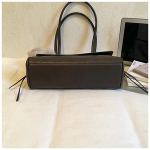 Detail of dark brown quilted shoulder bag with leather tassels and fluffy charm