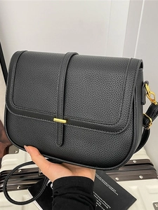 Sac bandoulière minimaliste en cuir noir avec boucle dorée et design de forme selle