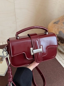 Chic burgundy patent leather crossbody bag with a metallic buckle for elegant women
