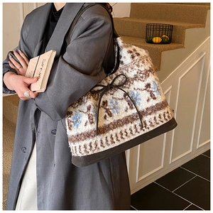 Detail of plush tote bag with vintage geometric pattern and brown leather bow detail