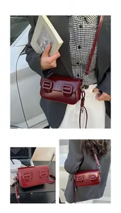 Polished wine red patent leather flap bag featuring large buckles and adjustable strap