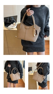 Detail der beigen Handtasche mit vertikaler Rippung und Perlenanhänger für Damen