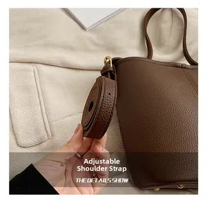 Détails de la bandoulière réglable et des ferrures dorées sur le sac en cuir grainé