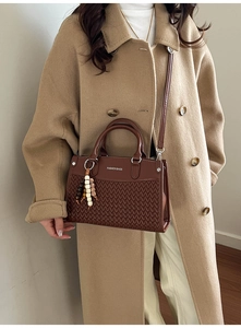 Close-up of woven texture and FASHION BAGS text on a dark brown women's handbag
