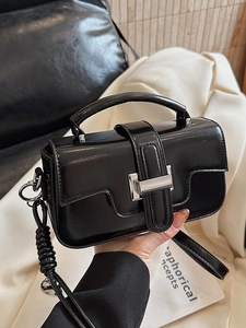 Minimalist black patent leather crossbody bag with braided knot strap and silver buckle