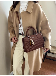 Detail of coffee brown woven leather bag featuring bead charms and crossbody strap