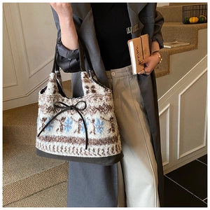 Detail of bohemian jacquard plush tote with leather base and decorative bow accent