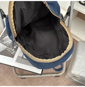 Détail intérieur du grand sac à dos en jean montrant le compartiment principal spacieux