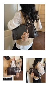 Detail of dark brown leather tote bag with silver rivets and cute plush bear charm