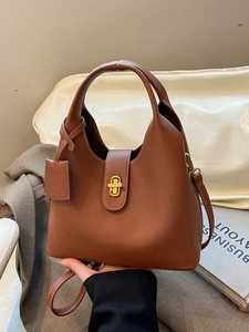 Brown lychee leather bucket bag with gold lock and top handle for elegant daily use