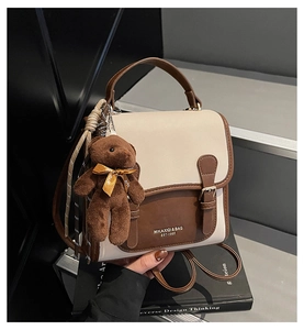 Detalle de la mochila en contraste con amuleto de oso en escaleras minimalistas