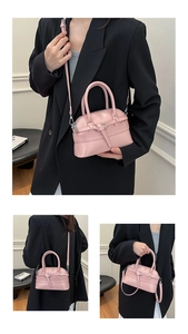 Pink crossbody bag with silver hardware and adjustable strap shown on a model