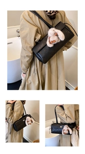 Detail of black quilted shoulder bag with plush rabbit charm and elegant flap closure