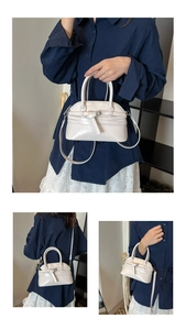 Close-up of cream glossy patent leather handbag showing the silver metal buckles and texture