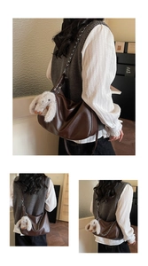 Brown hobo shoulder bag with silver chain and cute plush rabbit charm on side view