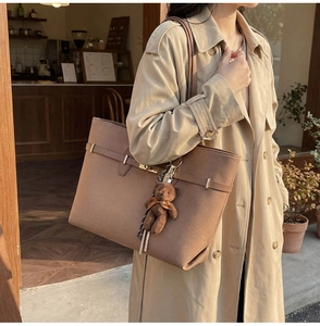 Detail of vintage large capacity tote bag in brown faux suede with cute bear pendant charm