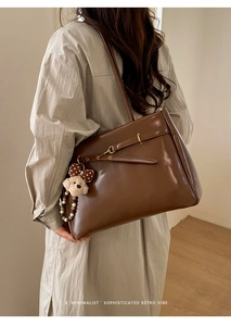 Retro deep brown tote bag styled with a plush bear charm on a minimalist model's shoulder