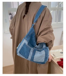 Model view of large denim tote bag featuring fringe details and patchwork blue panels