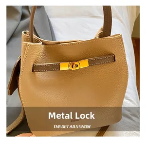 Gros plan du fermoir doré et du cuir grainé sur le sac à main de style seau