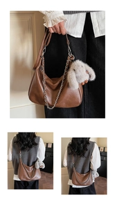Detail of a brown shoulder bag with a silver chain and a plush rabbit charm accessory