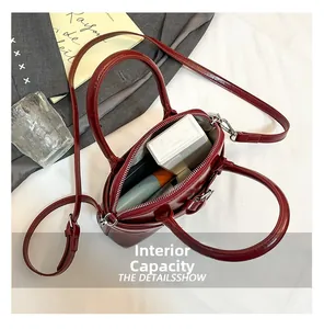Deep red patent leather handbag interior showing large capacity and smooth zipper