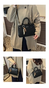 Detail view showing woven texture leather handbag with beaded charm and fashion lettering