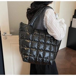 Borsa tote trapuntata di grande capacità con trama in nylon lucido vista su modella
