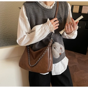 Detail of brown faux leather hobo bag with silver chain strap and plush rabbit charm
