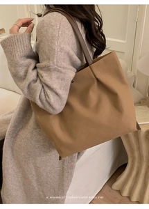 Minimalist canvas tote bag with leather strap shown in an outdoor lifestyle setting