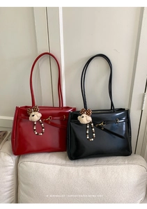 Detail of red and black glossy retro tote bags with cute teddy bear and bow accessories