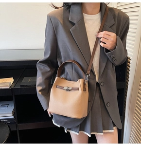 Close-up of retro brown leather bucket bag with metal buckle and shoulder strap
