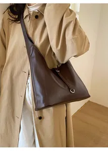 Macro shot of dark brown leather hobo bag with sleek metal ring buckle on shoulder strap