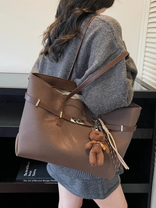 Retro coffee brown large tote bag with bear charm shown on model in a minimalist setting