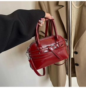 Detail of dark red PU leather square handbag with belt buckle and silver hardware