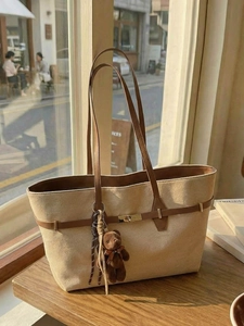 Vintage beige canvas tote bag with brown leather straps and a cute plush bear charm