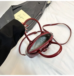Detail view of the deep red patent leather mini bag interior with light gray lining
